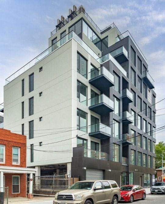 Full exterior view of a modern mixed-use building with windows and balconies