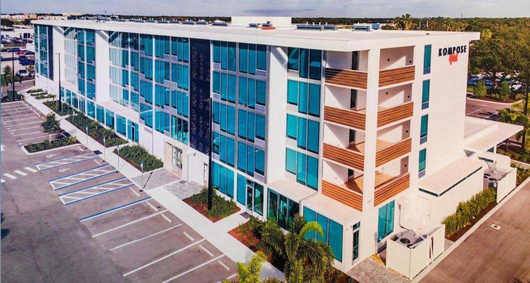Aerial view of a multistory hotel with extensive blue-tinted window glazing