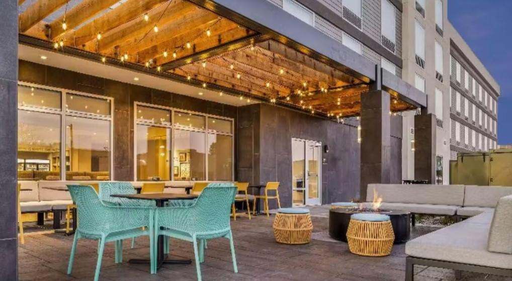 Covered hotel terrace with floor-to-ceiling storefront glazing