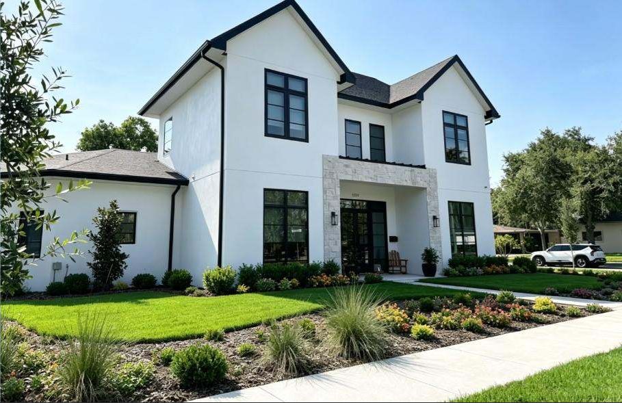 Full view of a completed two-story white residence with black-framed impact windows