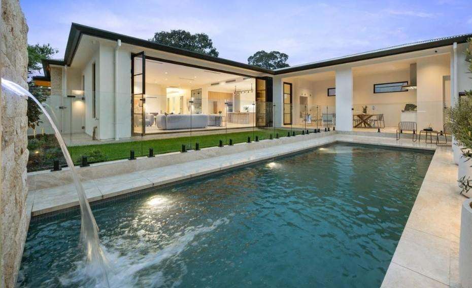 Modern residence with floor-to-ceiling glazing surrounding a pool courtyard