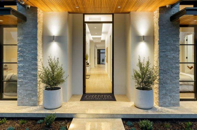 Illuminated contemporary residential entry with a full-height glazed door