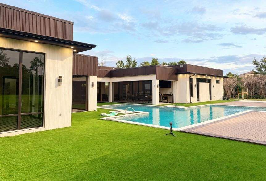 Full rear view of a contemporary single-story pool residence with expansive black-framed glazing